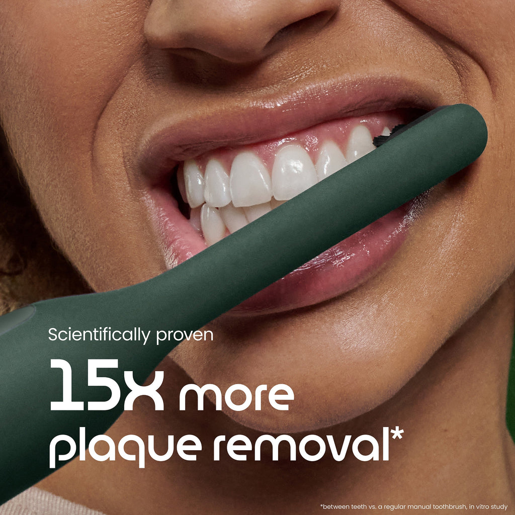 Teeth with a green toothbrush and text about plaque removal