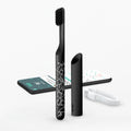 A smart rechargeable sonic toothbrush with a black handle and a geometric pattern, accompanied by a travel cover, a brush head, and a magnetic USB-A cable.