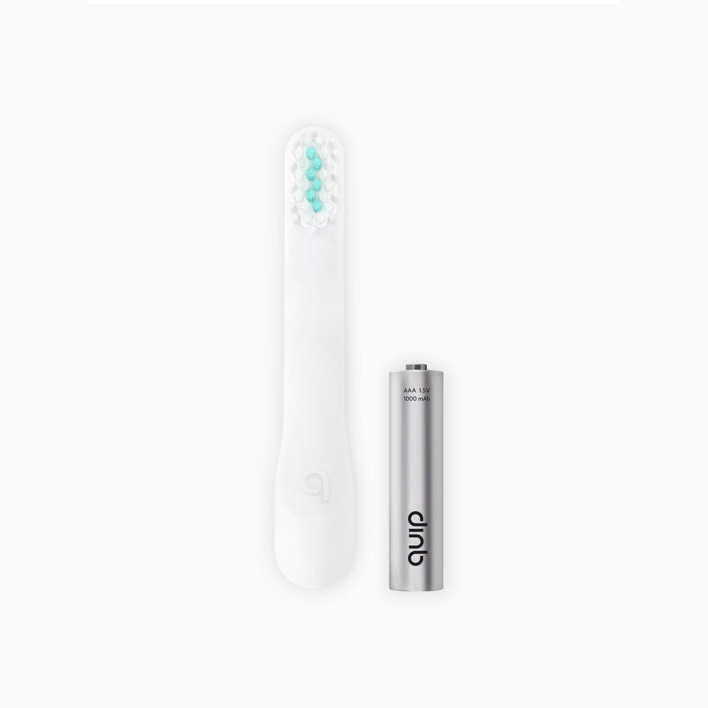An image showing a white toothbrush brush head refill next to an AAA battery.