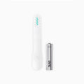 An image showing a white toothbrush brush head refill next to an AAA battery.
