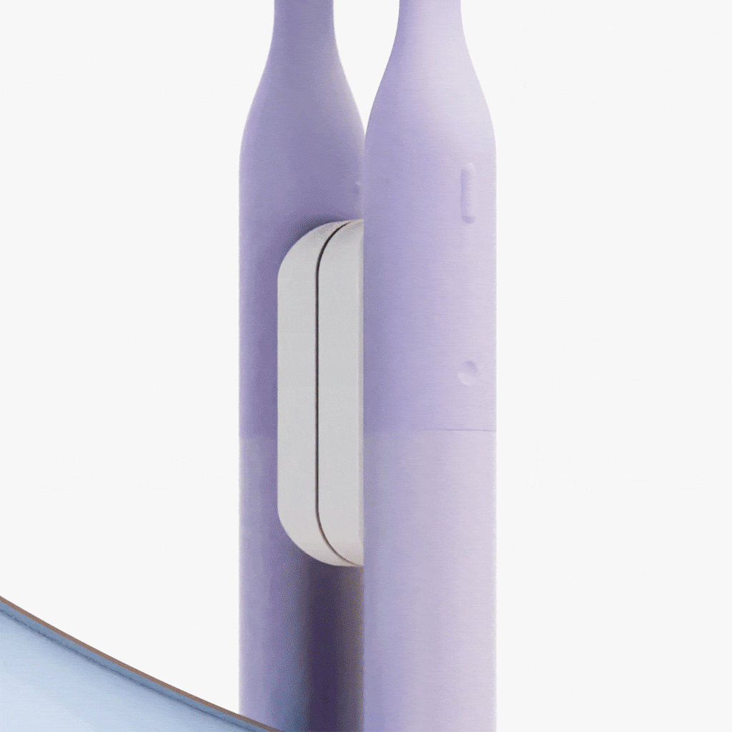 Close-up of a purple electric toothbrush handle with a white power button, shown against a clean white background.