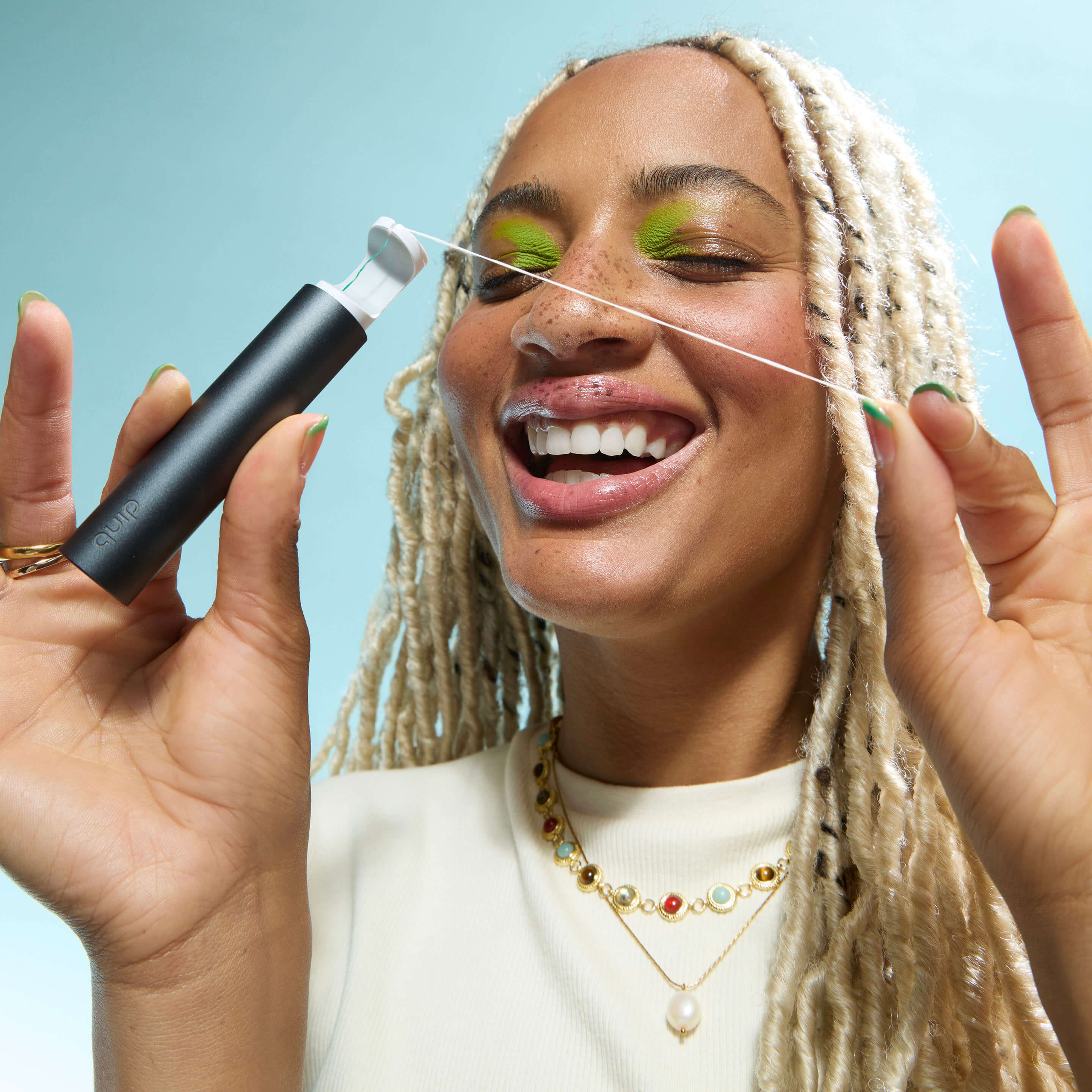 Woman using a threading tool on her face against a blue background