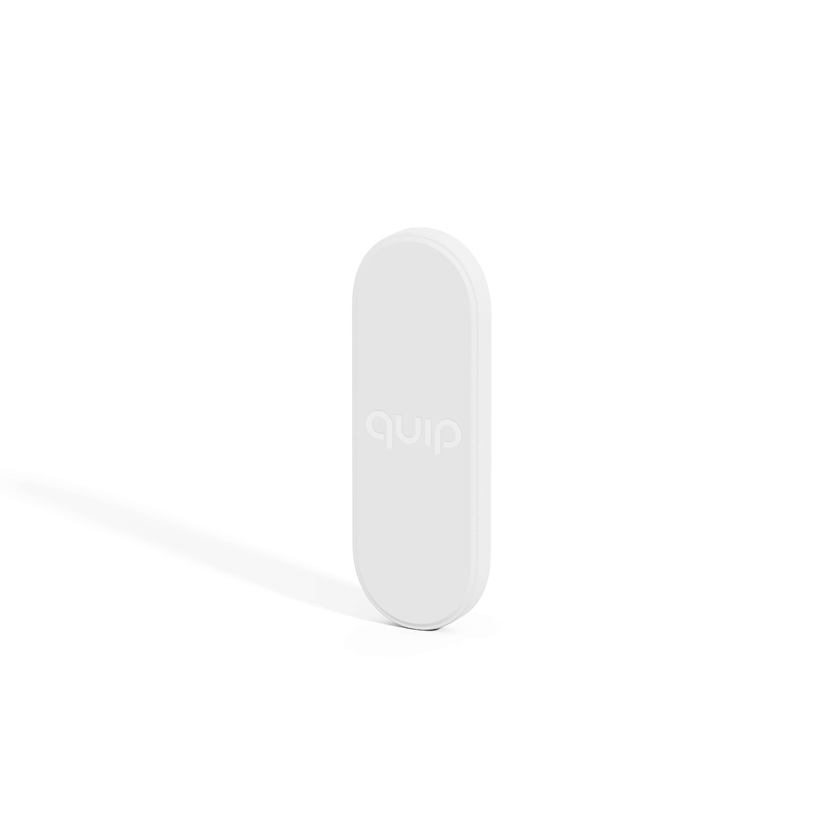 A white magnetic toothbrush holder with the word 'quip' inscribed on it, designed to mount on a flat surface.