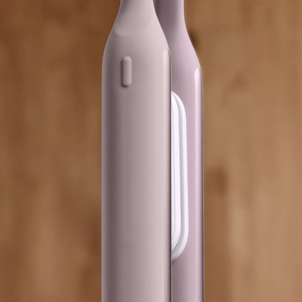 Close-up of a pink electronic device with a blurred wooden background