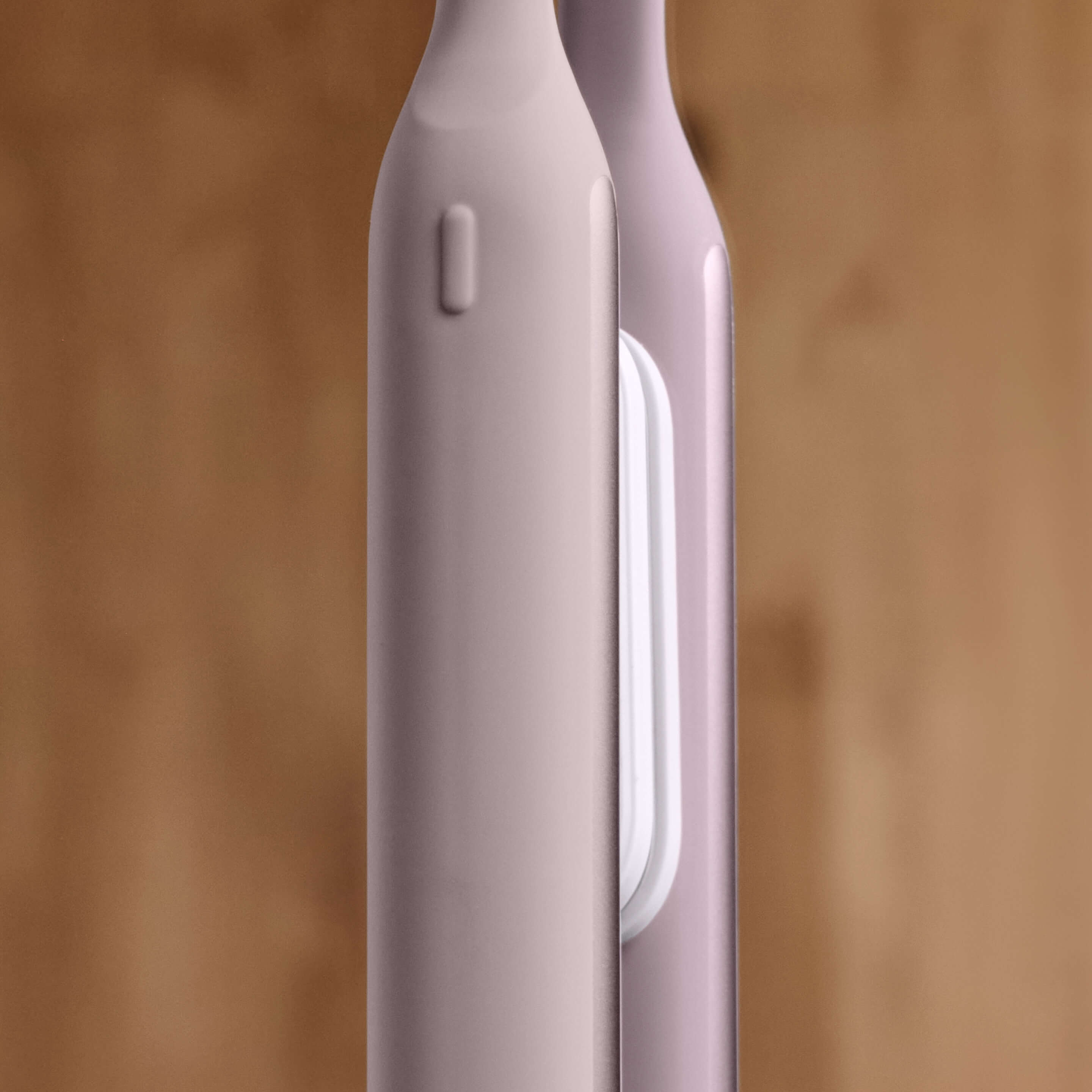 Close-up of a pink electronic device with a blurred wooden background