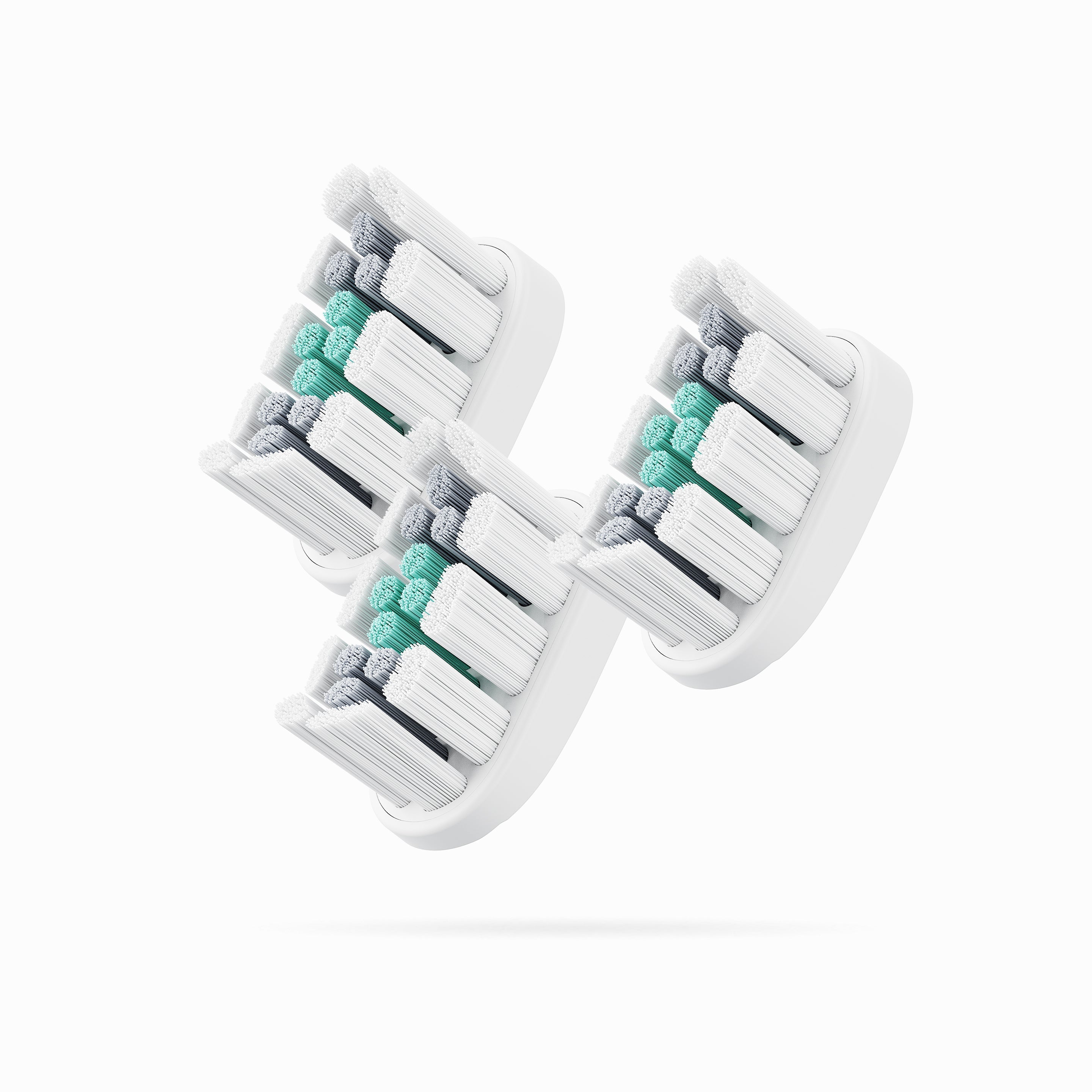 Three toothbrush heads with green and gray bristles on a white background