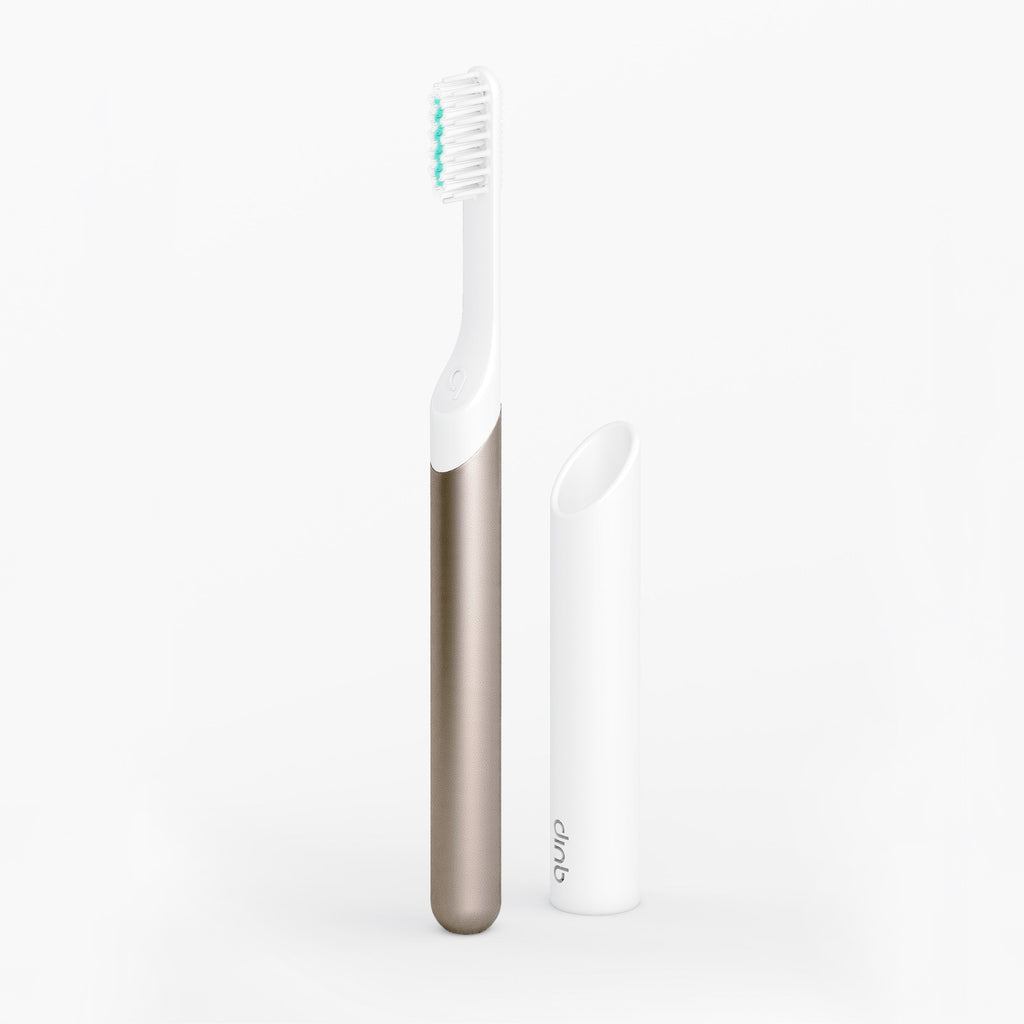Metallic Sonic toothbrush standing upright beside its white travel cover on a clean white background.