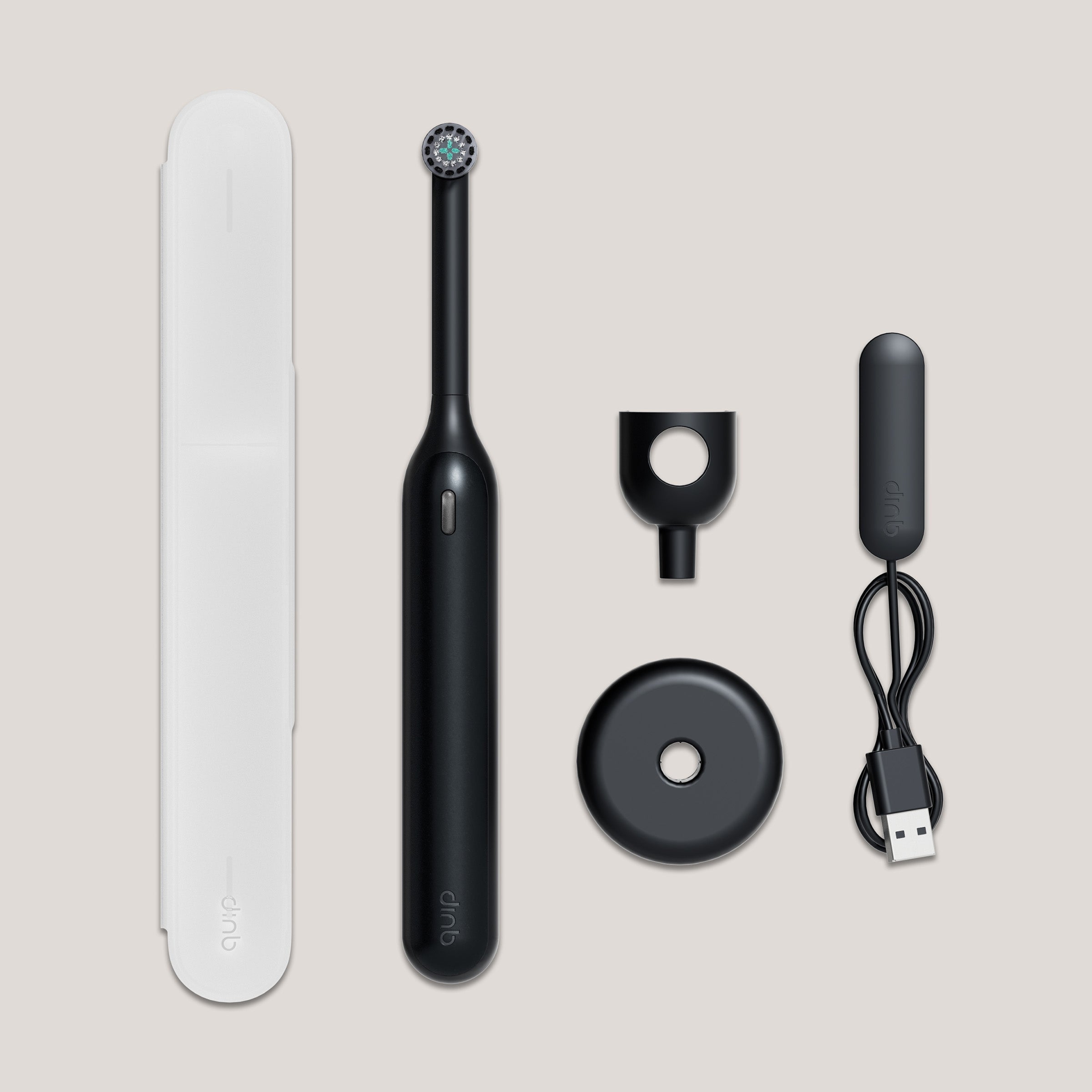 Black dental cleaning device with accessories on a beige background