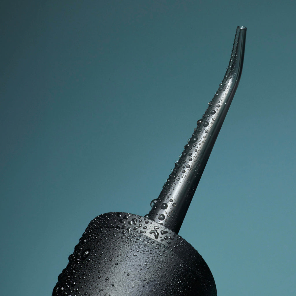 Black argolla with water droplets on a teal background