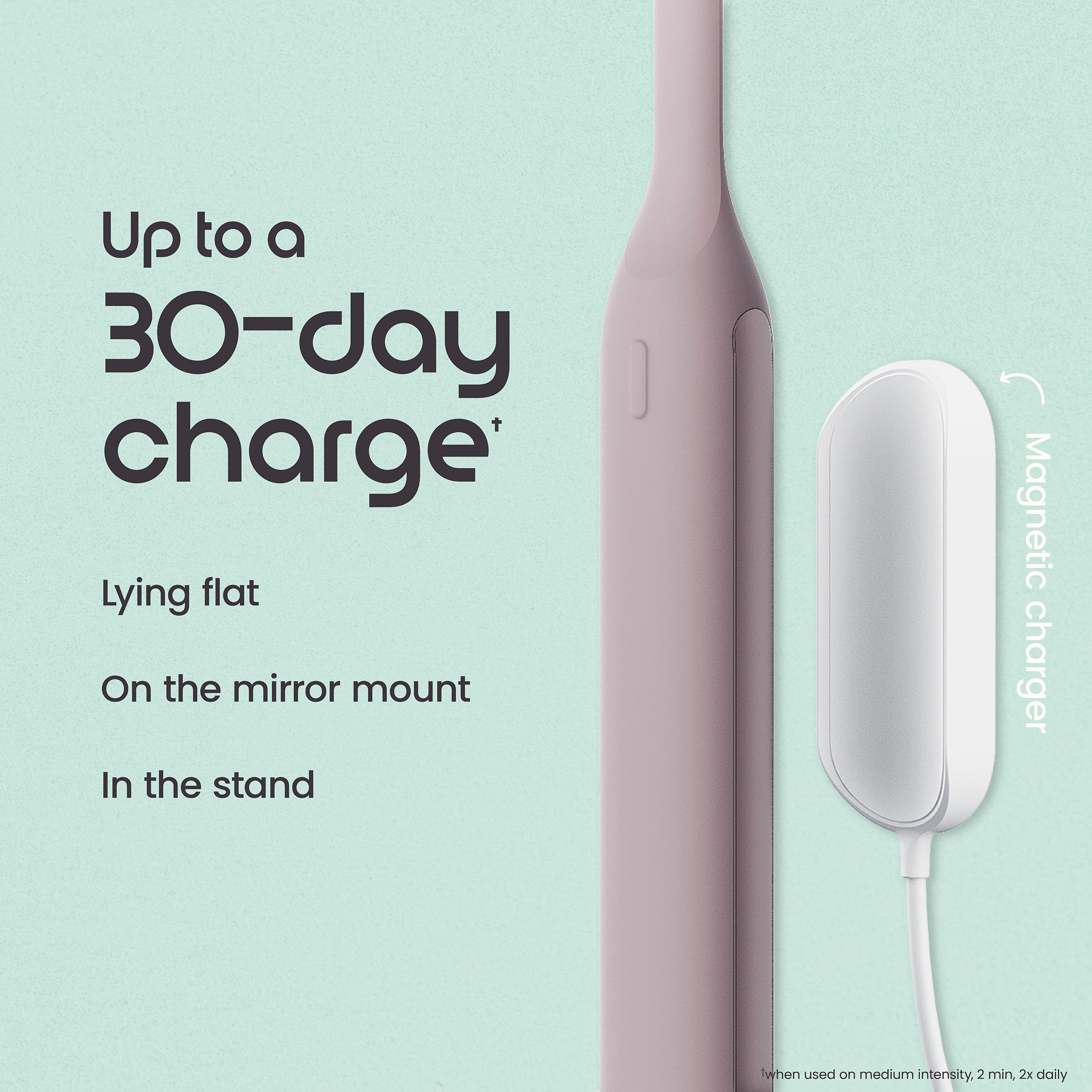 Pink electric toothbrush with charging stand on a light green background