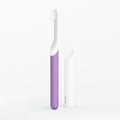 Purple and white toothbrush on a light gray background