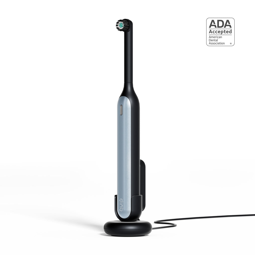 Black and silver electric toothbrush with charging stand on a white background, featuring ADA Acceptance logo.