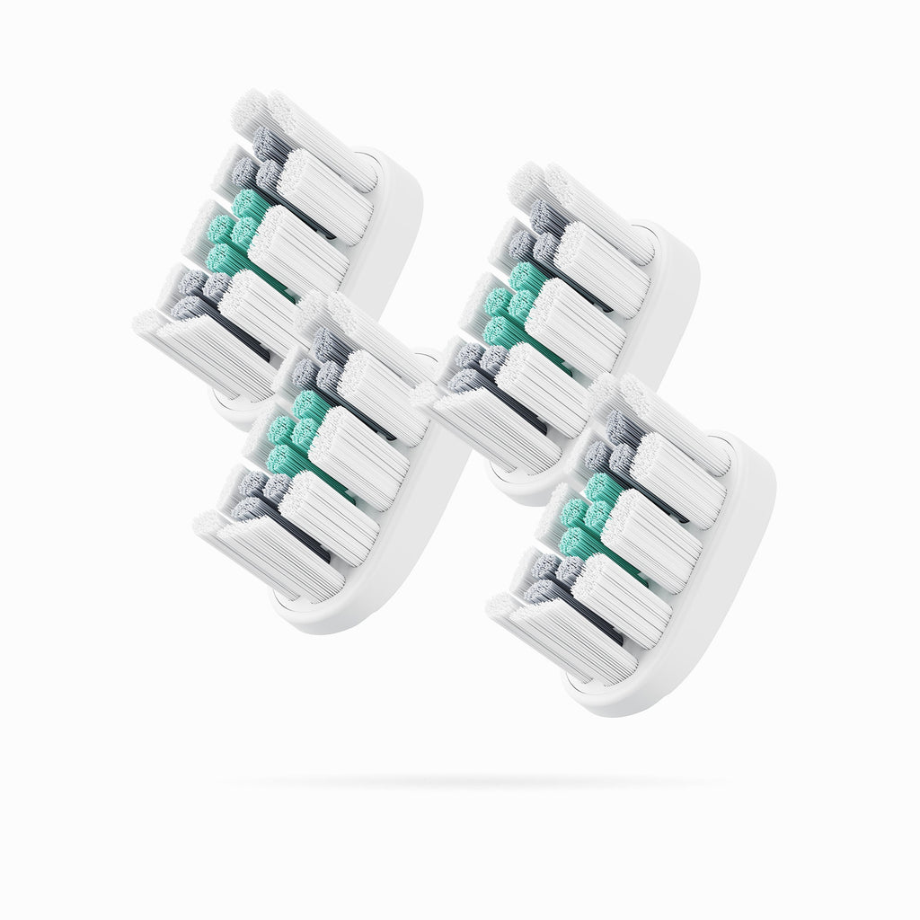Four toothbrush heads with white, gray, and green bristles on a white background