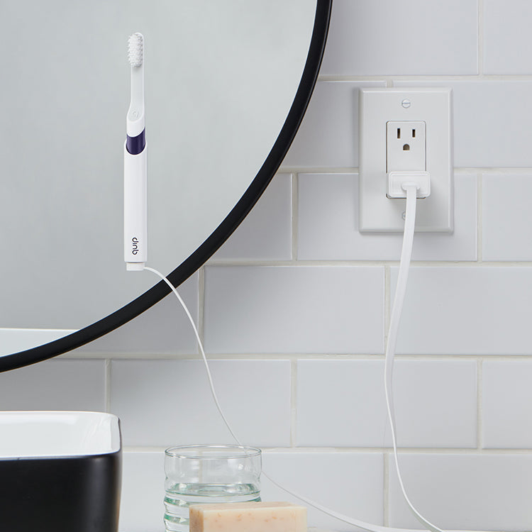quip Sonic Rechargeable Toothbrush mounted on the bathroom mirror while getting charged