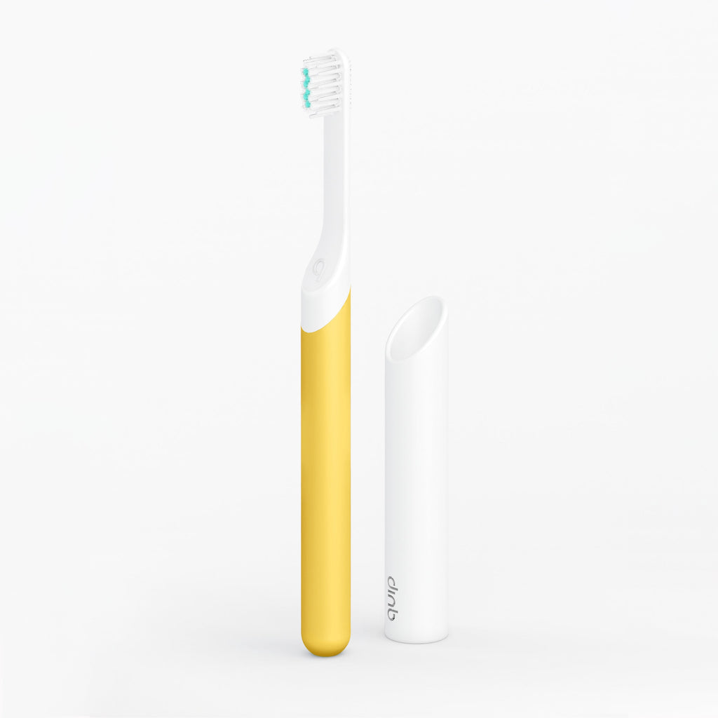 A kids sonic toothbrush with a yellow handle and white brush head, displayed alongside its travel cover/mount.